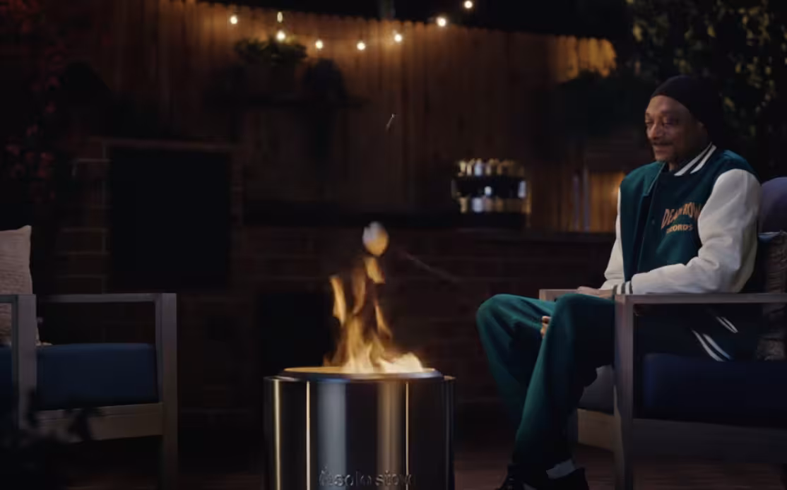 Snoop Dogg roasts a marshmallow outside over a Solo Stove smokeless firepit.