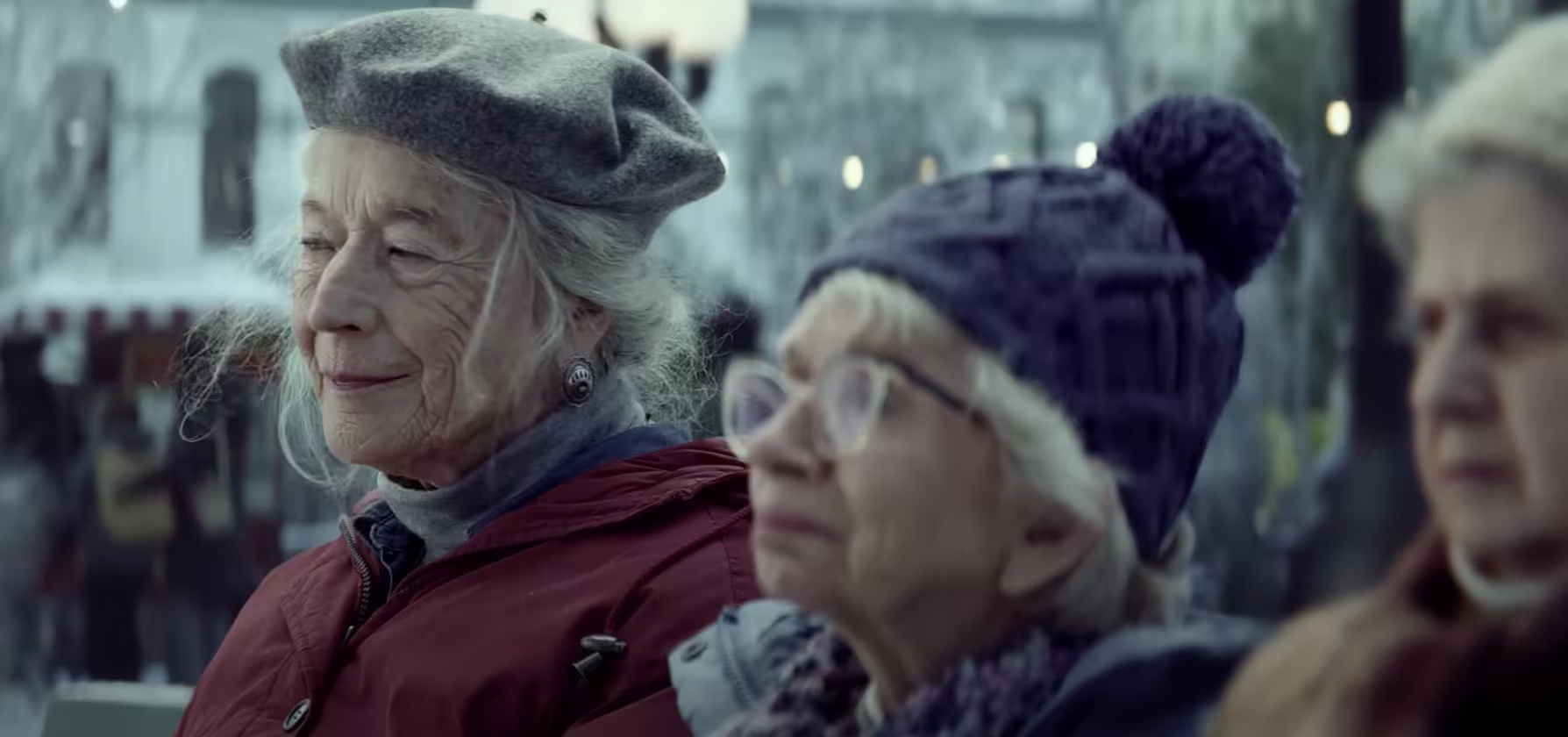 Three elderly women sit on a bench in the slow