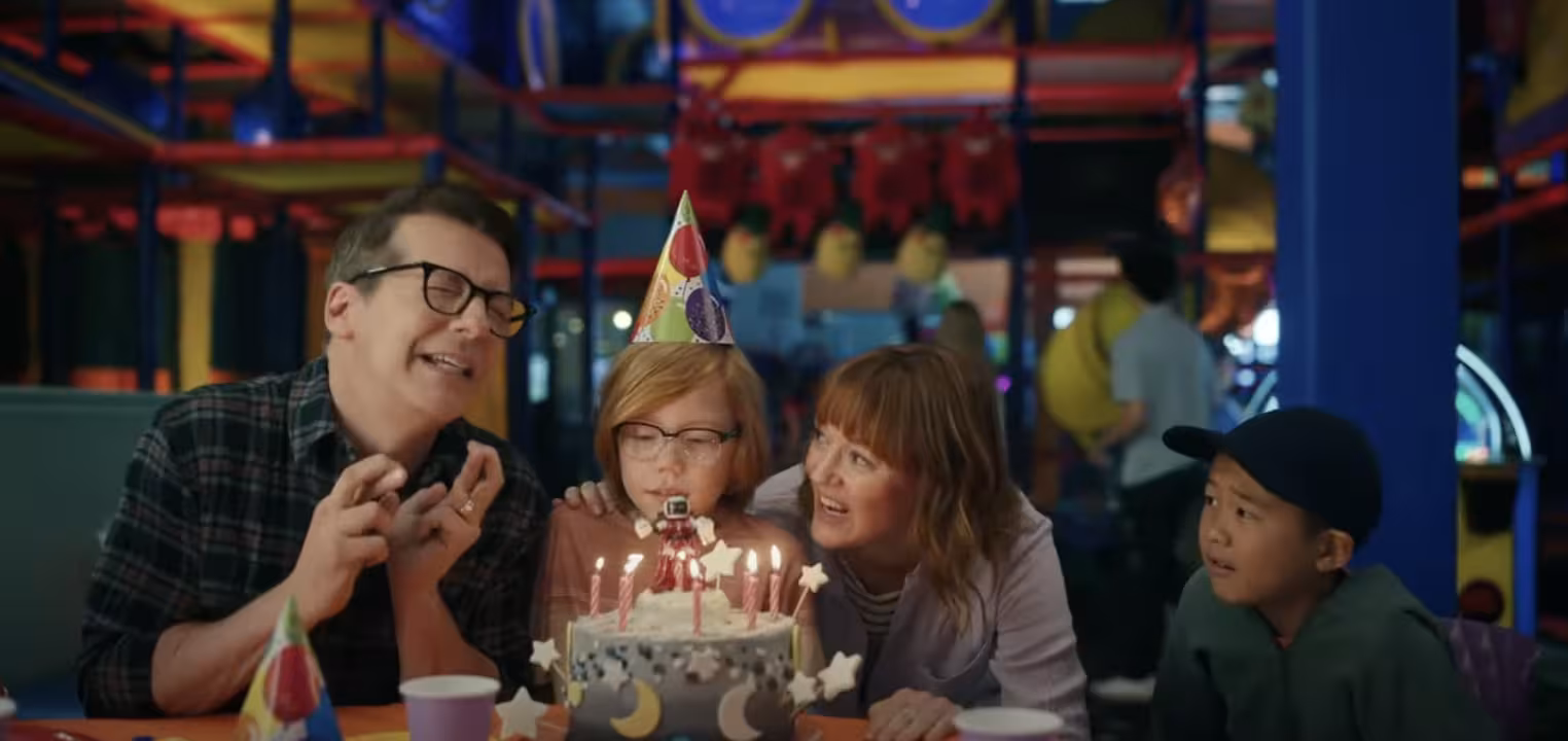 Sean Hayes appears with a family at a play place around a birthday cake