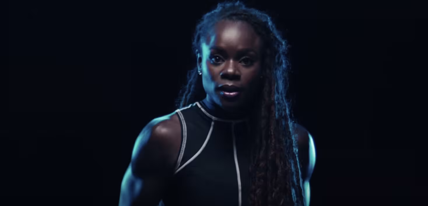 Tunde Oyeneyin cast in a blue light with a black backdrop